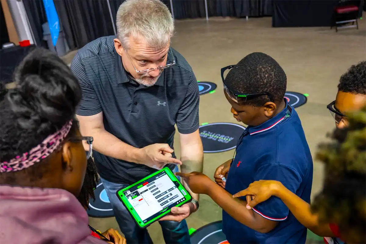 Tim Heffernan instructing students on For-The-Win Robotics Drone Controllers